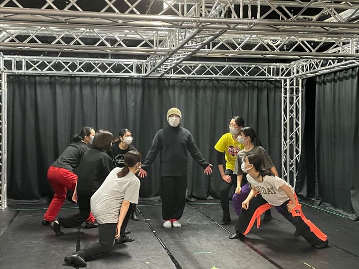 中央で両手を広げる出演者を、低い姿勢の団員たちが取り囲む場面｜劇団カスタリア 配信公演 通し稽古