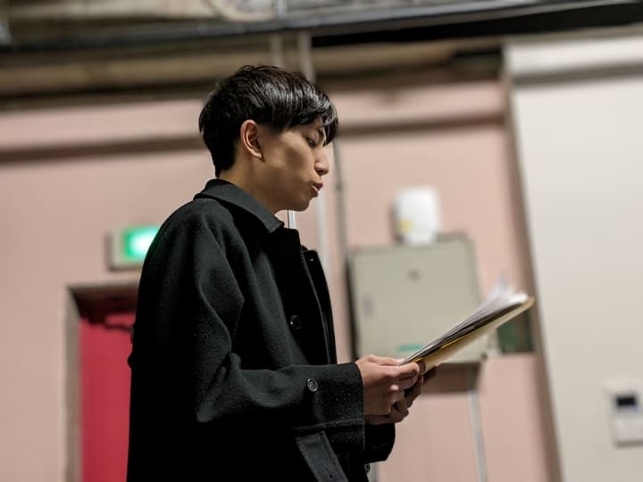譜面を手に、口を開いて自由曲を歌う団員｜劇団カスタリア 歌の特訓
