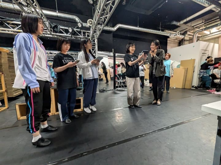 タブレットを手に、講師の説明を聞きながら振りを覚える出演者たち｜劇団カスタリア「清子と桃香」振り付け稽古