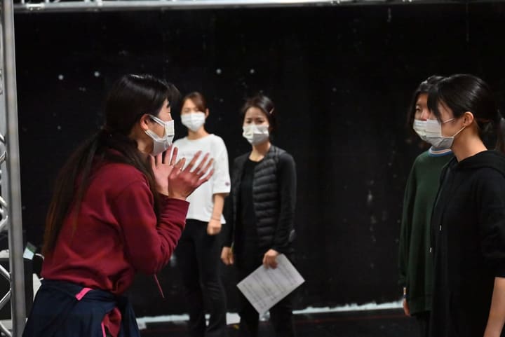 手ぶりを交えた指導に、譜面を手にした出演者が耳を傾ける|劇団カスタリア ナンバー稽古