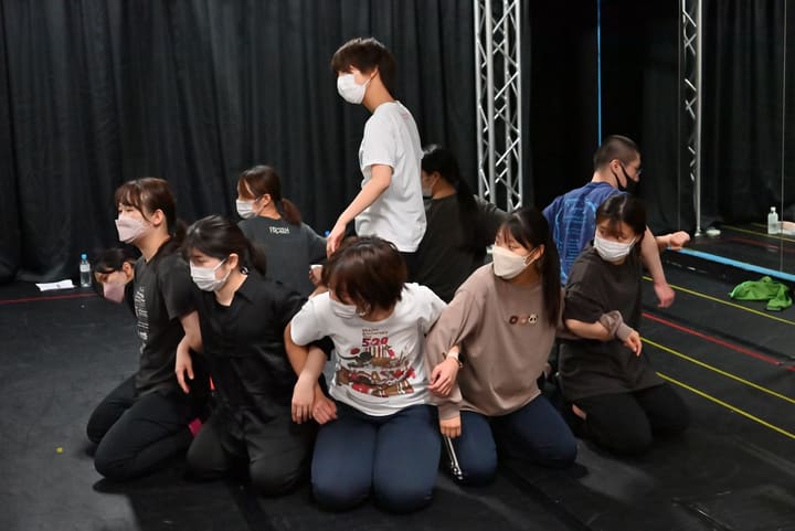 膝立ちで一列に並ぶ出演者と、その後ろに立つ団員の隊形｜劇団カスタリア「オーブ」ダンス稽古