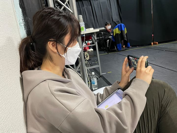 壁際に座りスマートフォンで映像を確認する団員｜劇団カスタリア「ルドベキア・フェスティバル」稽古