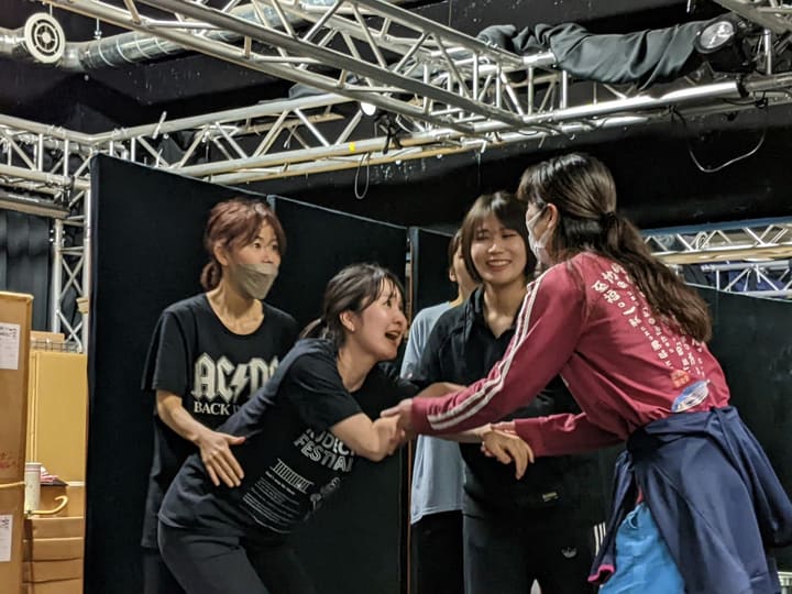 笑い合いながら手を取り合い、もみ合う場面を演じる出演者たち｜劇団カスタリア 立ち稽古