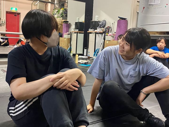 床に座り、笑いながら言葉を交わす団員2人｜劇団カスタリア 稽古オフショット