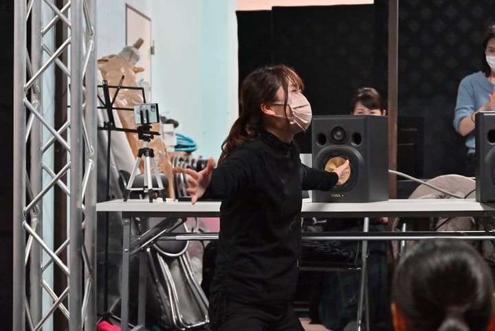 両腕を大きく広げて演じる団員をスタッフが後方から見守る|劇団カスタリア「オーブ」稽古
