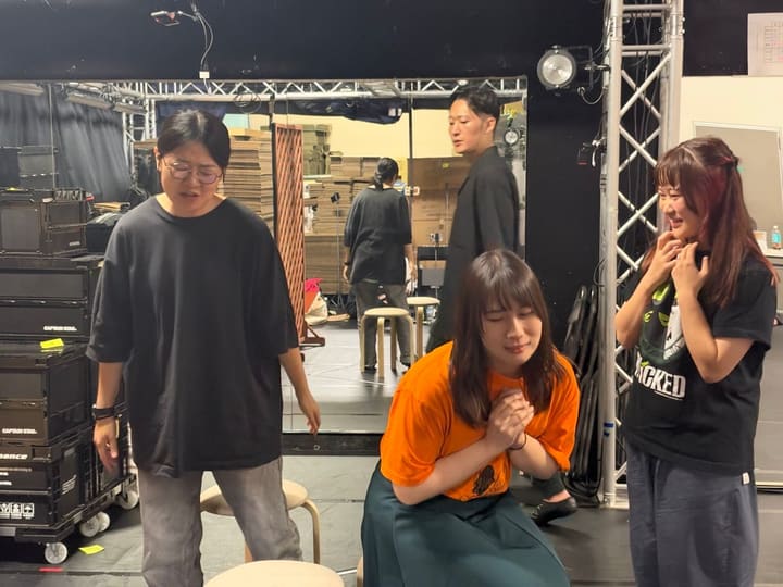 椅子に腰かけ、手を合わせて祈るような表情を見せる出演者｜劇団カスタリア 芝居稽古