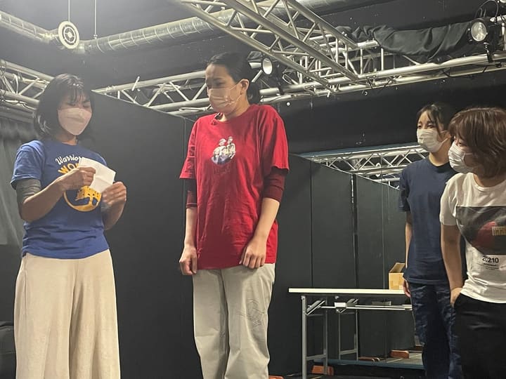 紙を手にした団員と横一列に並んで立つ出演者4人｜劇団カスタリア 立ち稽古