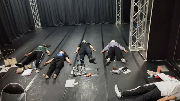稽古場の床に仰向けに寝て脱力し、呼吸を整える団員たち|劇団カスタリア 歌稽古