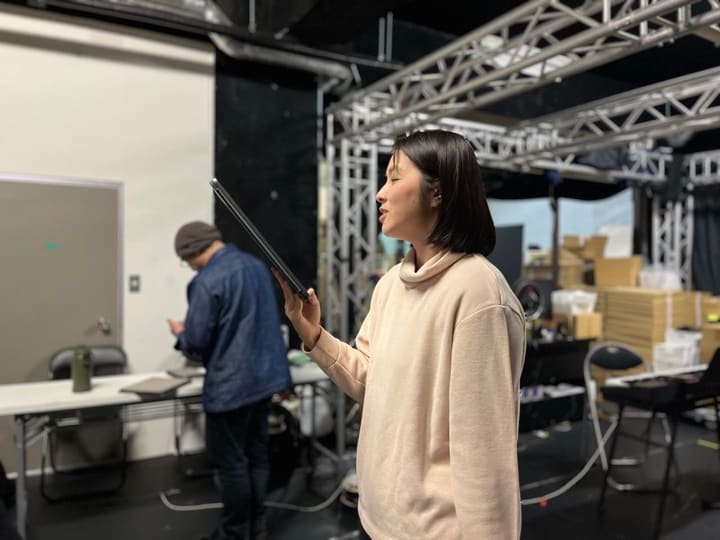 タブレットの台本を掲げ、目を閉じてせりふを口にする団員|劇団カスタリア「清子と桃香」芝居稽古