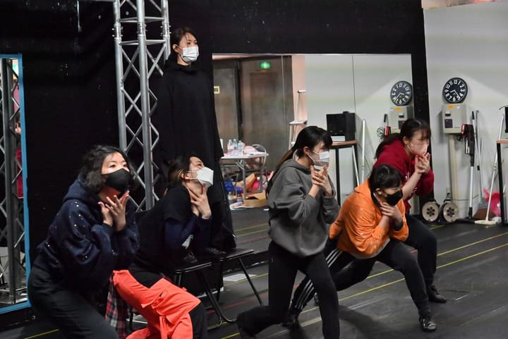 中腰になり両手を顔の横に構えるポーズをそろえる団員たち｜劇団カスタリア 振付稽古