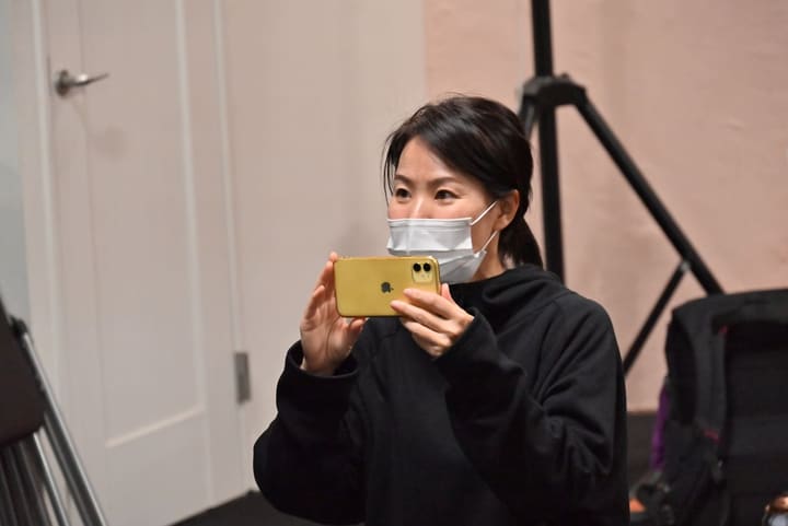 スマートフォンを横向きに構えて稽古場の様子を撮影する団員｜劇団カスタリア 稽古後の動画撮影