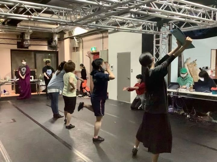 稽古場に広がって振付をさらう団員と、机で見守るスタッフ｜劇団カスタリア ステージング稽古