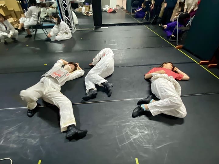 白いつなぎの衣裳のまま床に寝そべって休む出演者3人｜劇団カスタリア 衣裳パレード