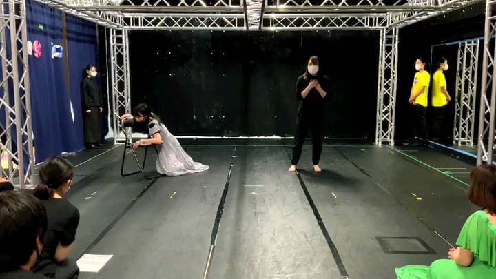 銀色のドレスで椅子にもたれる出演者と、胸に手を当てて立つ出演者｜劇団カスタリア ソング＆ダンス通し稽古