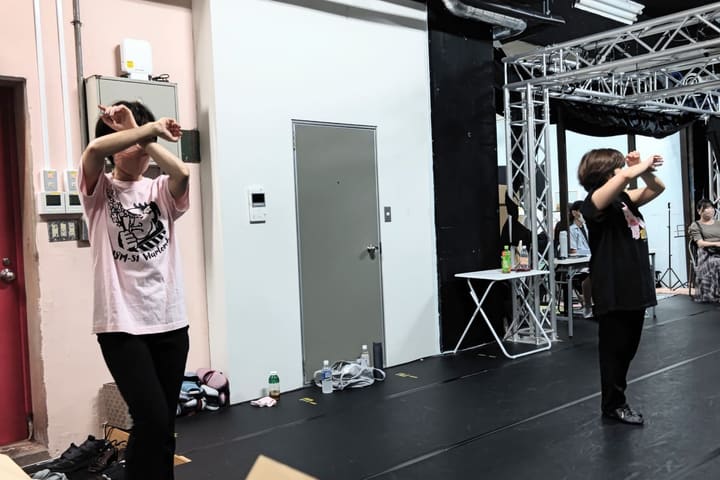 両腕を顔の前で交差させる振りを繰り返し確かめる団員たち|劇団カスタリア ダンス稽古
