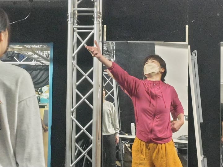 腕を斜め上へ突き出し、視線を上げて踊る講師｜劇団カスタリア ダンス基礎練習
