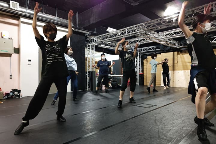 両腕を頭上に上げ、全員で振りをそろえて踊る団員たち｜劇団カスタリア ダンス稽古