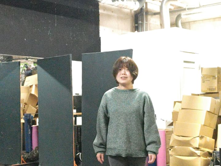 黒いパネルの前に立ち、笑顔でせりふを口にする団員｜劇団カスタリア 演技稽古