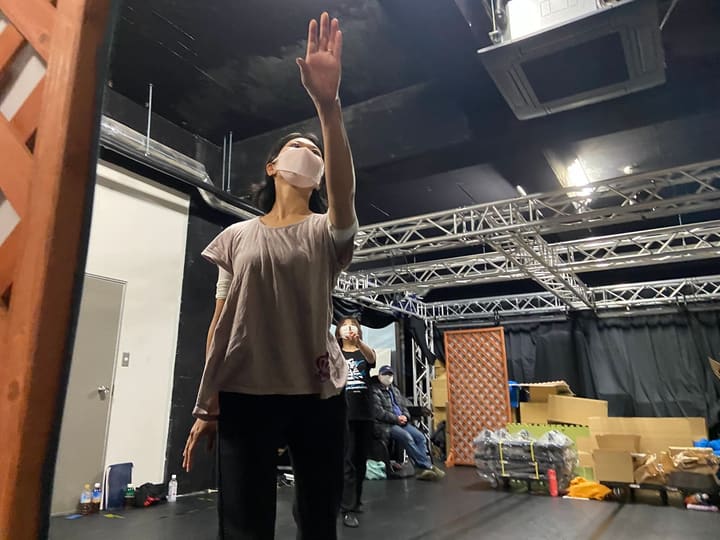 片手をまっすぐ天井へ伸ばし、指先を見上げる団員｜劇団カスタリア ダンス稽古