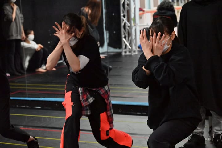 両手を顔の前に広げ、片膝を落として決めポーズをとる団員2人｜劇団カスタリア ダンスナンバー稽古