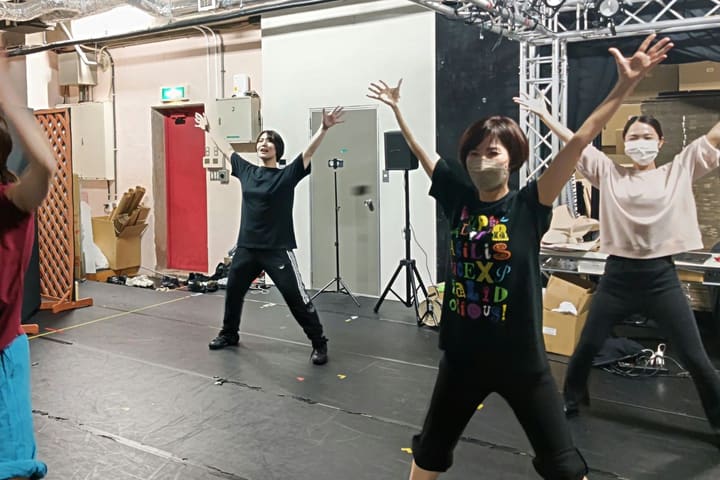両腕を頭上いっぱいに広げて振りを合わせる団員たち｜劇団カスタリア ダンス稽古