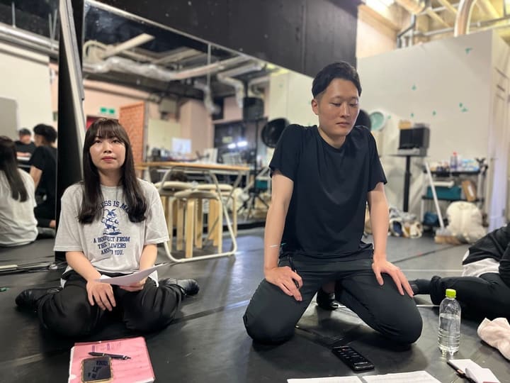 稽古場の床に座り、演出の説明に耳を傾ける出演者｜劇団カスタリア 芝居稽古