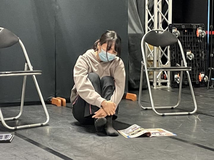 床に開いた求人誌の横で、ひざを抱えて座り込む場面|劇団カスタリア 演技稽古