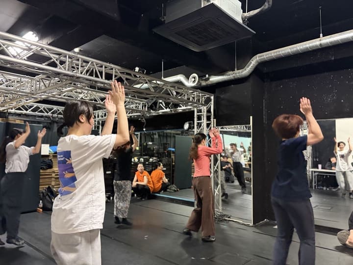 両手を頭上に上げ、鏡に向かって全員で振りを揃えるダンス基礎練習｜劇団カスタリア「金曜日の食卓」稽古