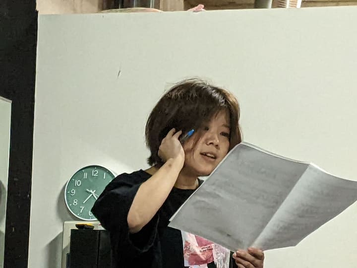 片手を耳に当て、譜面を見ながら声を確かめる団員｜劇団カスタリア 歌稽古
