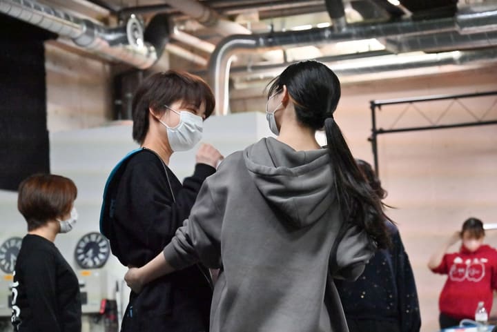 向かい合って手の所作を確かめ合う団員2人と、見守る仲間｜劇団カスタリア 振付稽古