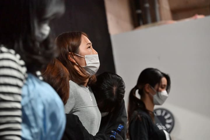 列に並んで待ちながら、前方の稽古をじっと見つめる団員たち|劇団カスタリア ダンス稽古