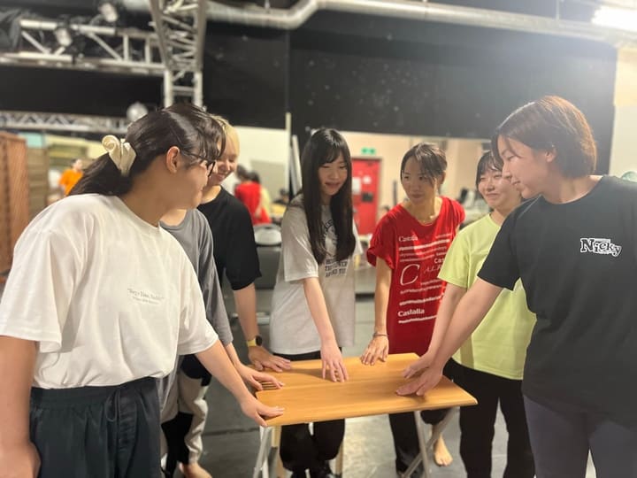 テーブルに手をつき、向かい合って振りを確かめる出演者たち｜劇団カスタリア 新曲の振り入れ