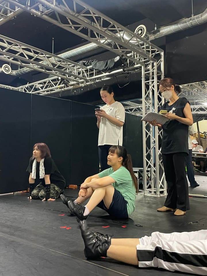 床に座り込み、譜面を手にした団員と次の場面を待つ出演者たち|劇団カスタリア「TRIP」通し稽古