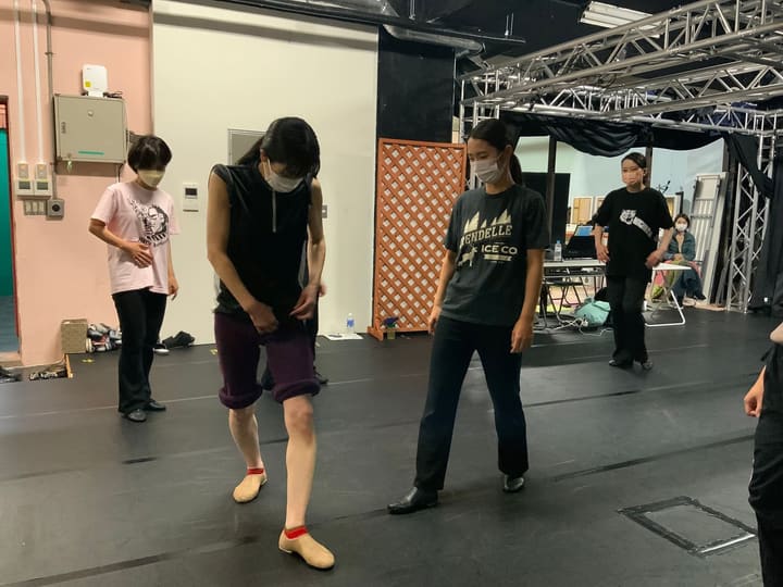 足元を見つめ、キャラクターシューズで足の運びを確かめる団員たち｜劇団カスタリア ダンス稽古