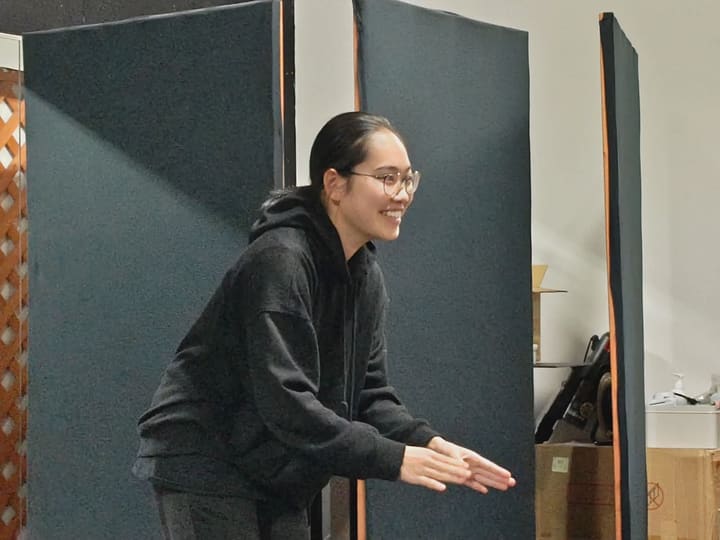 前かがみで両手を差し出し、笑顔で相手に語りかける団員｜劇団カスタリア 演技稽古