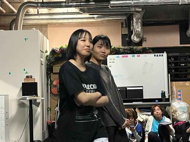 腕を組んで背中合わせに立ち、掛け合いを演じる団員2人|劇団カスタリア「清子と桃香」芝居稽古