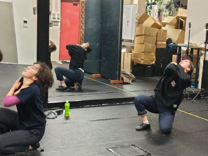 片膝をついて頭の後ろで手を組み、上体を反らす団員たち｜劇団カスタリア ダンス稽古