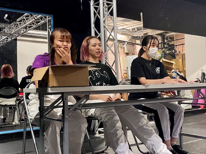 長机の奥にパイプ椅子を並べて座り、仲間の稽古を見つめる団員3人｜劇団カスタリア「ルドベキアフェスティバル」稽古