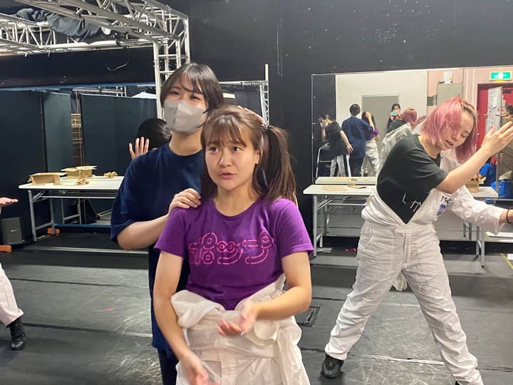 白い衣裳をまとい、髪を直してもらいながら振りを確認する出演者｜劇団カスタリア 衣裳パレード