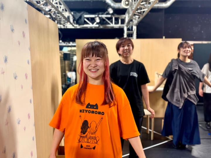 稽古場の段ボールの陰から顔を出し、笑顔を見せる川埜まゆ｜劇団カスタリア 稽古日誌#202