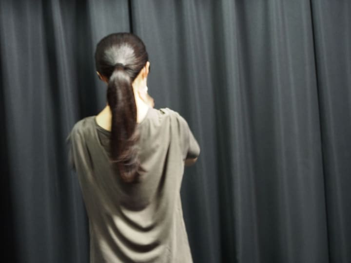 暗幕に向かって立ち、後ろ姿のまま出番を待つ団員｜劇団カスタリア 演技稽古