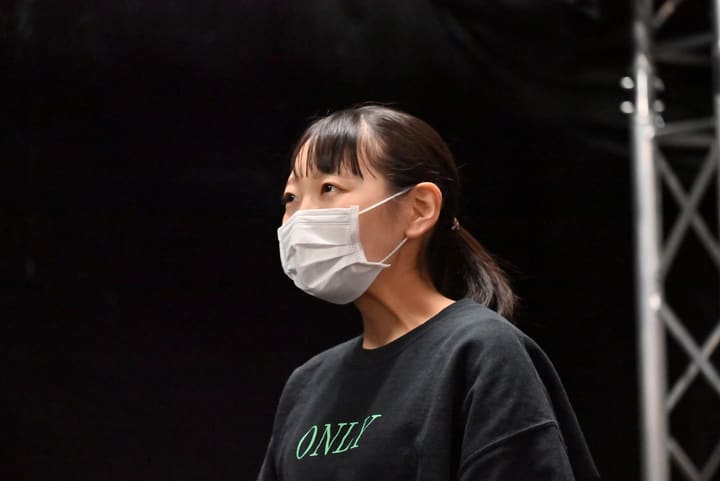 黒いトレーナー姿で、暗い舞台の先をじっと見つめる団員の横顔|劇団カスタリア ナンバー稽古