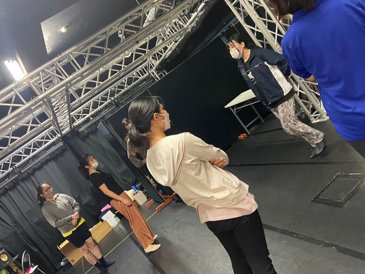 腰に手を当てて振り返る団員と、それを見つめる団員たち|劇団カスタリア ダンス稽古