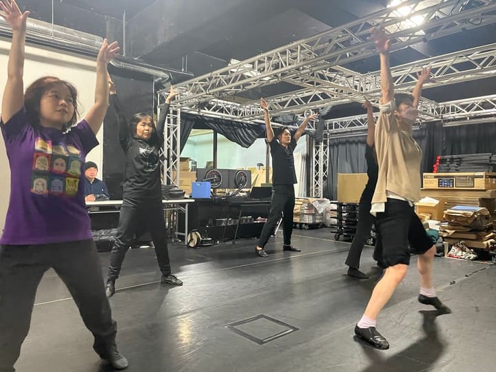 両腕を頭上に伸ばし、脚を開いた姿勢でそろえるダンス稽古|劇団カスタリア オーディションに向けた稽古