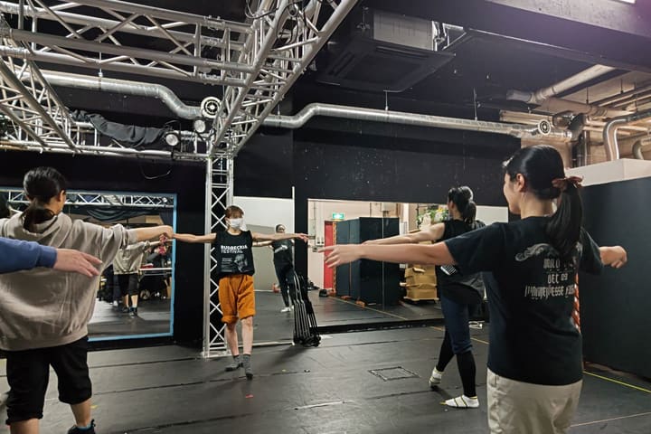 両腕を左右に伸ばし、鏡を見ながら動きをそろえる団員たち｜劇団カスタリア ダンス基礎練習