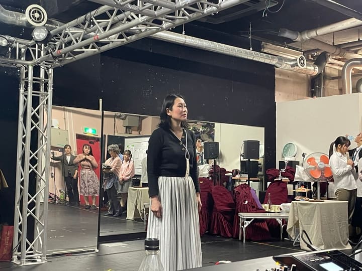 縞のスカート姿で舞台中央に立ち、正面を見据える出演者｜劇団カスタリア「TRIP」通し稽古