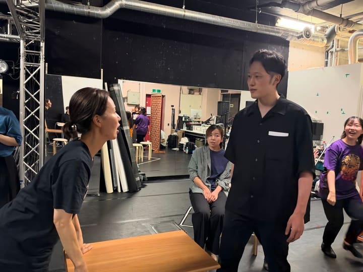机をはさんで向かい合い、台詞をぶつけ合う出演者｜劇団カスタリア 芝居稽古