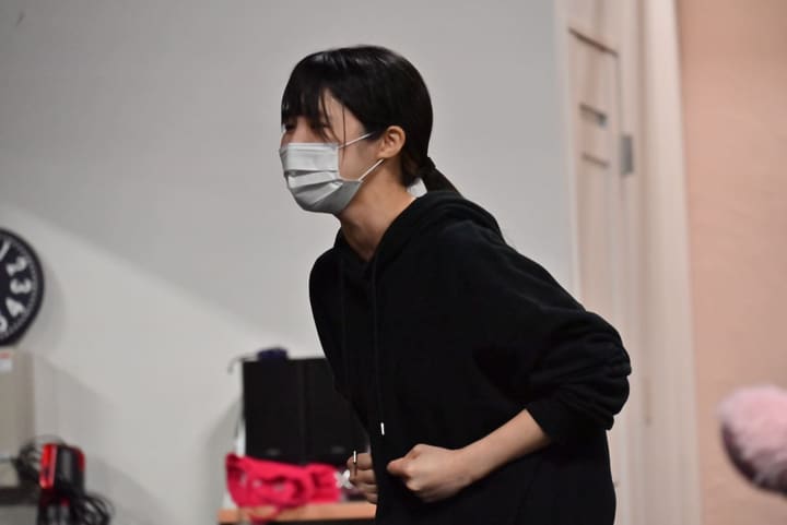 両手を軽く握って構え、前を見据える黒い上着姿の団員｜劇団カスタリア 2幕の通し稽古