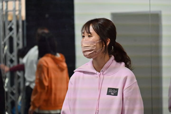 淡いピンクのパーカー姿で、稽古の進行を見つめる団員|劇団カスタリア ナンバー稽古