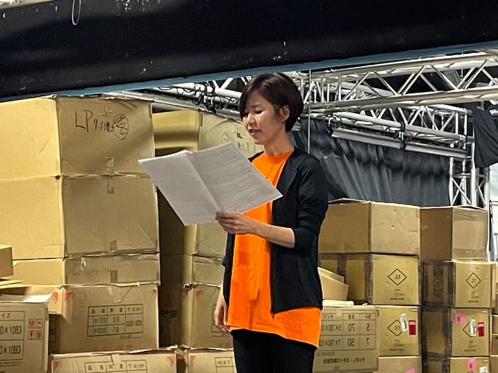 積み上げた段ボール箱の前で、台本を開いて読む団員｜劇団カスタリア 演技稽古